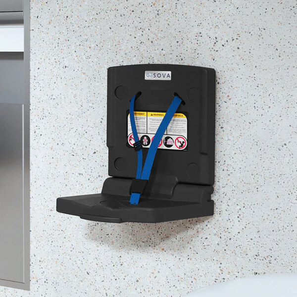 A black wall-mounted toddler safety seat with blue safety straps.