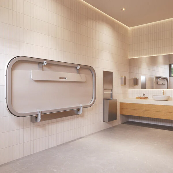 A wall-mounted adult changing station in a modern restroom setting.