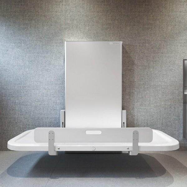 A wall-mounted, height-adjustable changing station with a fold-down table and safety rail.