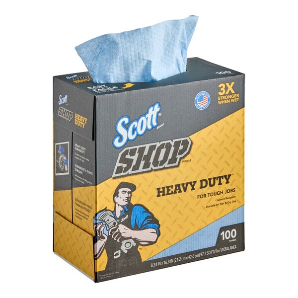 A box of Scott Shop heavy duty blue towels with one towel partially pulled out from the top.