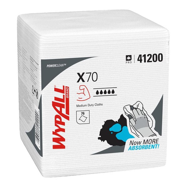 A stack of white, folded cloths in a rectangular package labeled 'WypAll X70' with product information and illustrations on the front.