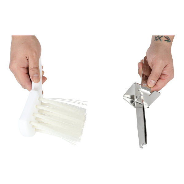 A two-piece cleaning kit consisting of a white brush and a metal pusher cleaning tool for use with the Saber King.