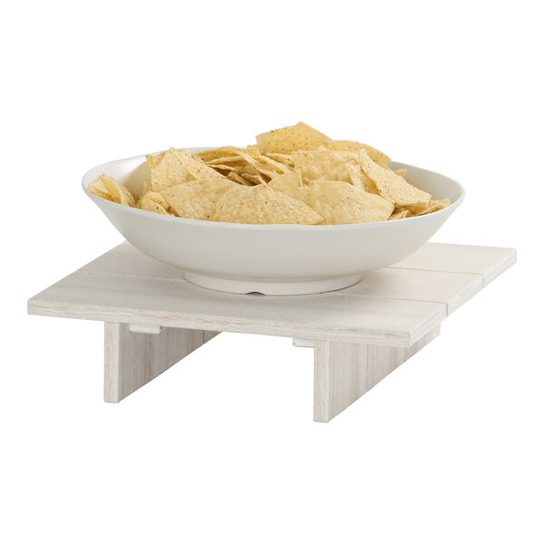 A white square display riser made of HDPE, shown holding a bowl of tortilla chips.