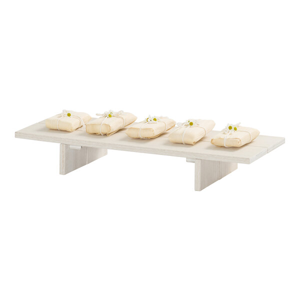 A rectangular coastal HDPE display riser with several wrapped items placed on top.