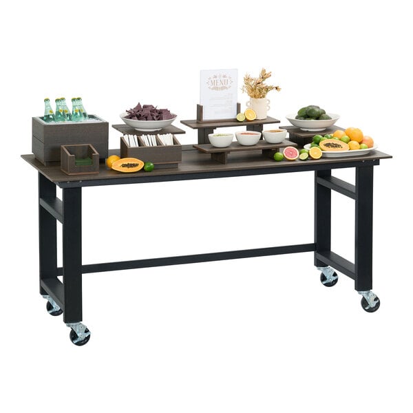 A large rectangular mocha-colored outdoor table or service cart with four casters, set up with various food and drink items.