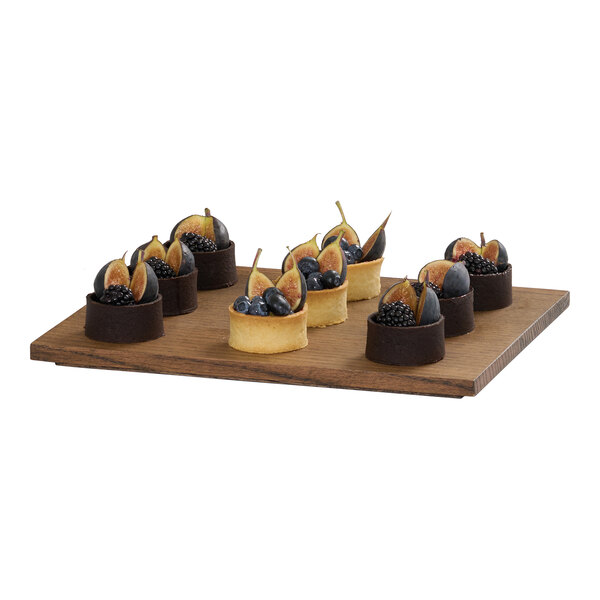 A rectangular chocolate brown oak wood tray displaying assorted fruit tarts.
