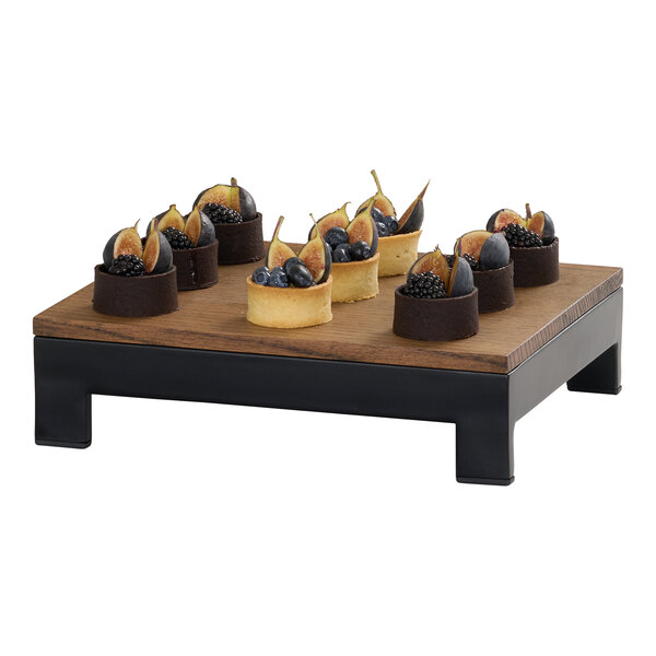 A rectangular chocolate brown oak wood tray with a flat surface and black legs, used for displaying food items.
