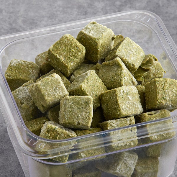 A container filled with greenish frozen smoothie cubes.