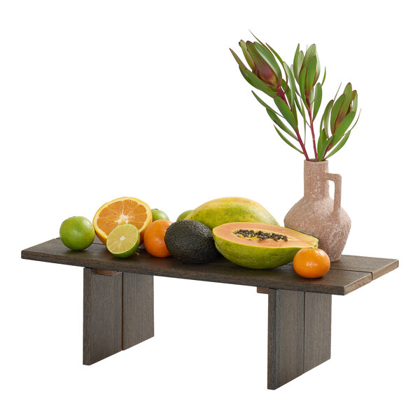 A rectangular mocha-colored HDPE display riser holding assorted fruits and a vase with greenery.