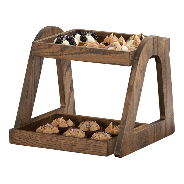 A two-tier angled merchandiser made of chocolate brown oak wood, displaying assorted desserts.