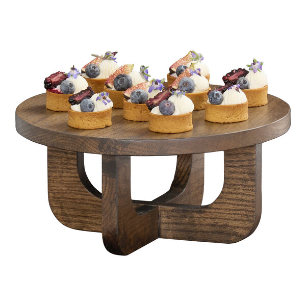 A round chocolate brown oak wood riser with a modern design, used for displaying food items.