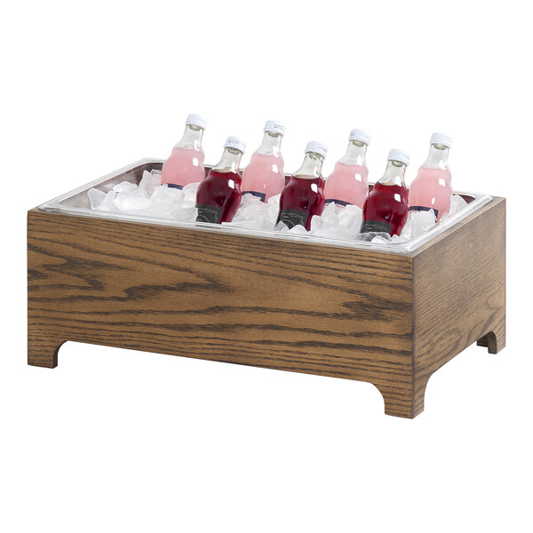 A wooden ice housing unit filled with ice and assorted bottled beverages.