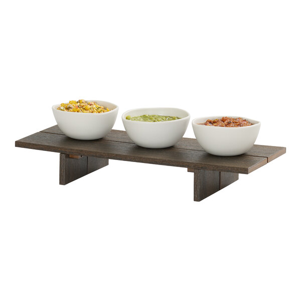 A rectangular mocha-colored HDPE display riser with three white bowls containing different foods placed on top.