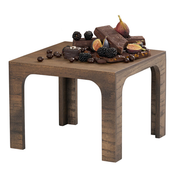 A square chocolate brown oak wood riser with a flat top and four legs.