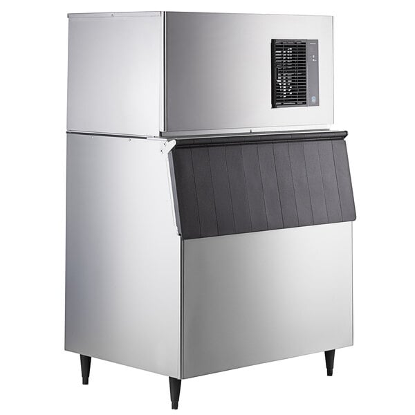 A commercial stainless steel ice machine with a black ice storage bin.