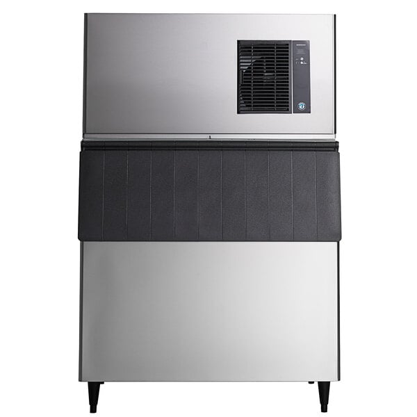 A commercial stainless steel ice machine with a black ice storage bin.