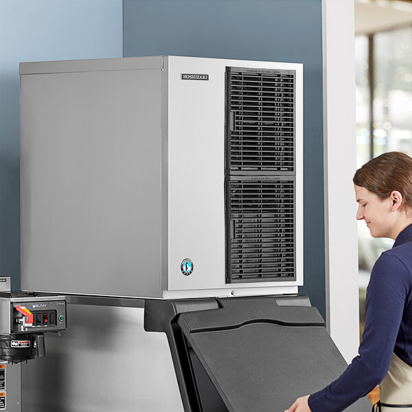 A stainless steel modular crescent ice machine with an air-cooled system and ice storage bin.
