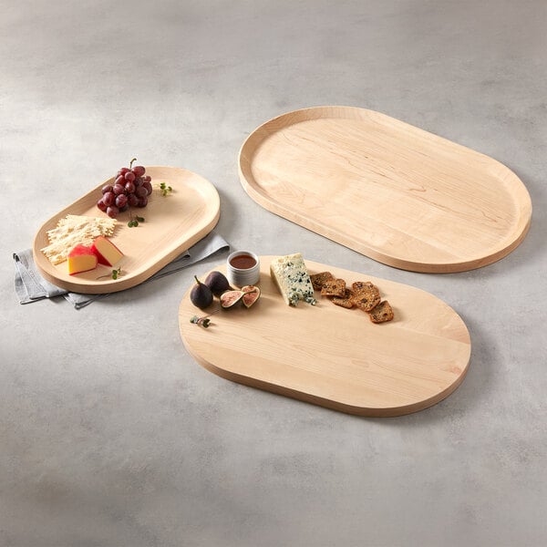 An oval maple wood serving board measuring 14 1/8 inches by 8 3/4 inches by 3/4 inch.