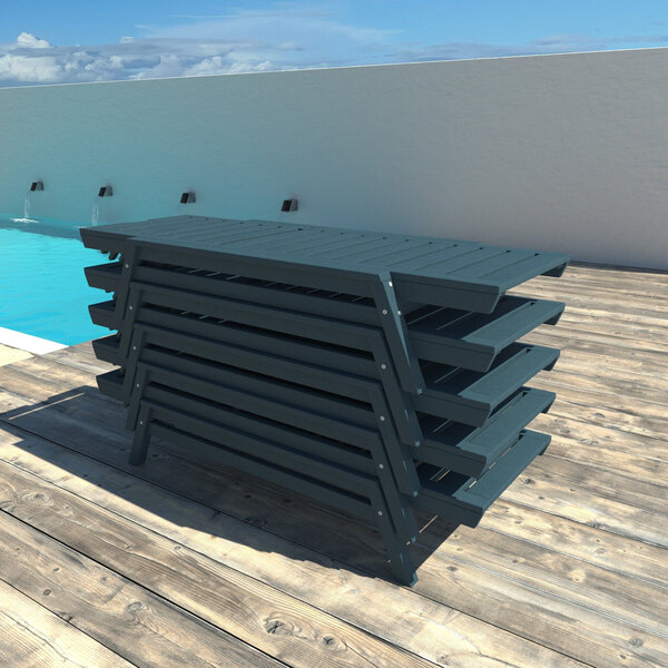 A stack of blue adjustable poly-lumber chaise lounges on a wooden deck by a pool.