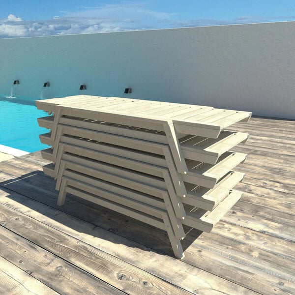 A stack of white wash adjustable poly-lumber chaise lounges on a wooden deck by a pool.