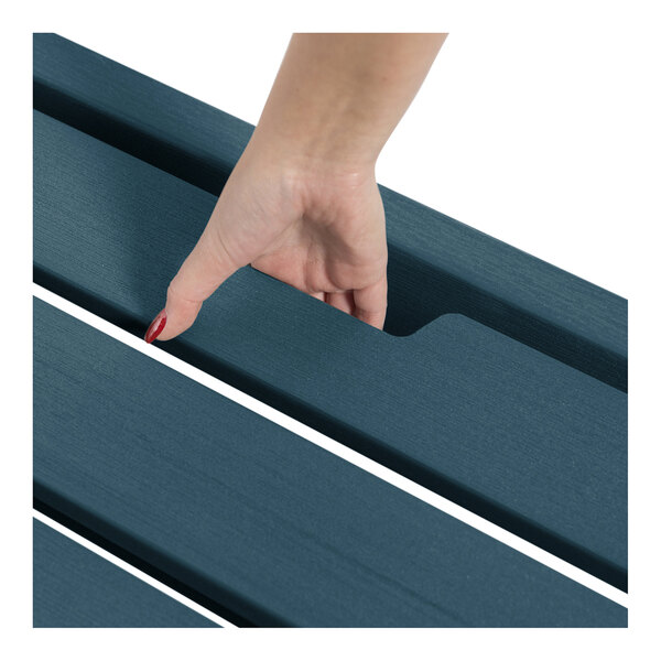 A hand lifting a slat on a blue adjustable stackable poly-lumber chaise lounge.