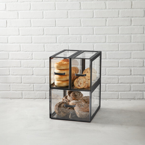 A black matte metal display case with three clear acrylic drawers, used for displaying baked goods.