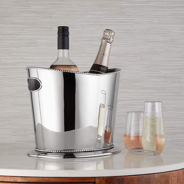 A polished stainless steel beaded wine bucket holding two bottles, designed to chill and serve wine.