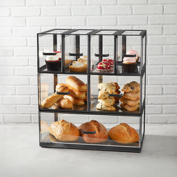 A full-size black matte metal display case with acrylic drawers, used for displaying baked goods.