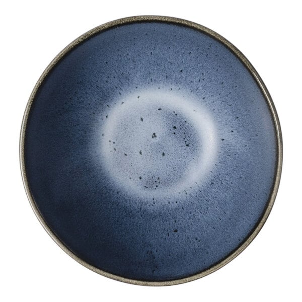 A round, matte blue porcelain bowl with a gradient design and a slightly speckled center.