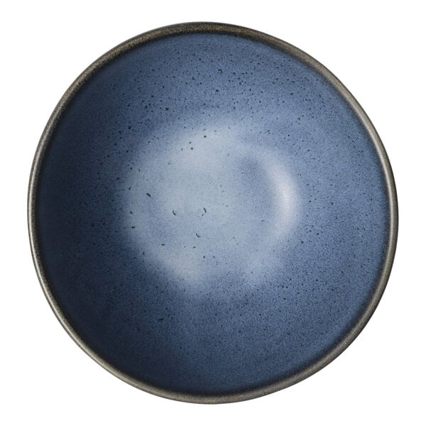 A round, matte blue porcelain bowl with a slightly speckled finish.