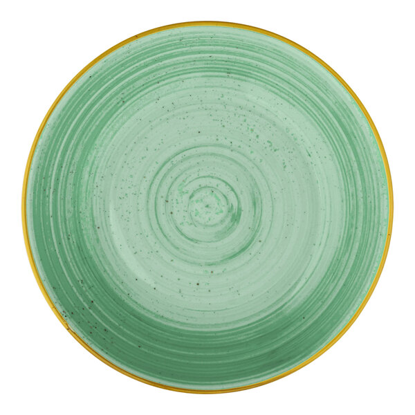 A round mint green deep coupe plate with a textured circular pattern and a yellow rim.