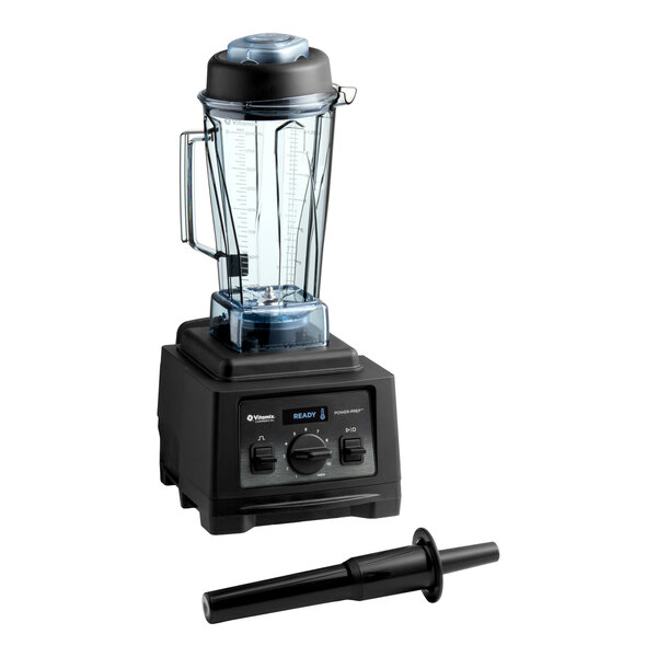 A commercial-grade Vitamix blender with a 64 oz. clear container and a black tamper tool.