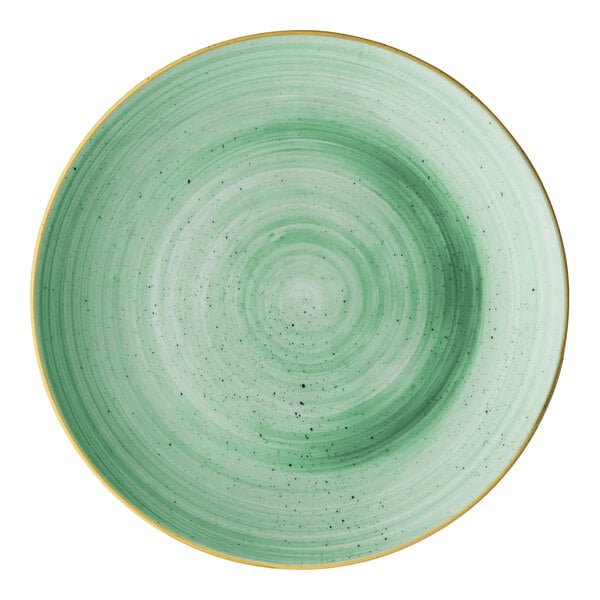 A round mint green porcelain coupe plate with a subtle speckled pattern and a gold rim.