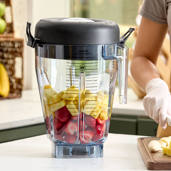 A large Vitamix 1.5 gallon Tritan container jar with a lid, filled with cut fruit.