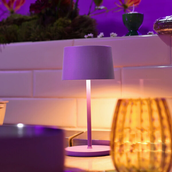A small lilac cordless rechargeable table lamp with a cylindrical shade and round base.