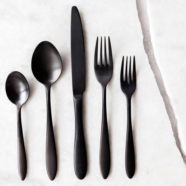 A set of matte black stainless steel flatware including a salad or dessert fork.