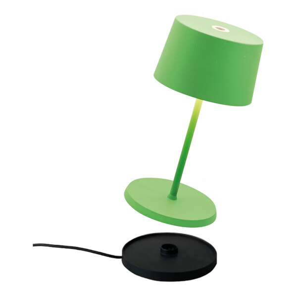 A small, apple green cordless rechargeable table lamp with a black charging base.