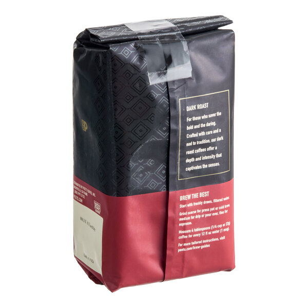 A sealed bag of ground coffee with a black and maroon design, featuring text about dark roast and brewing instructions on the side.
