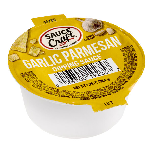 A single-serve cup of Sauce Craft Garlic Parmesan dipping sauce with a yellow foil lid.