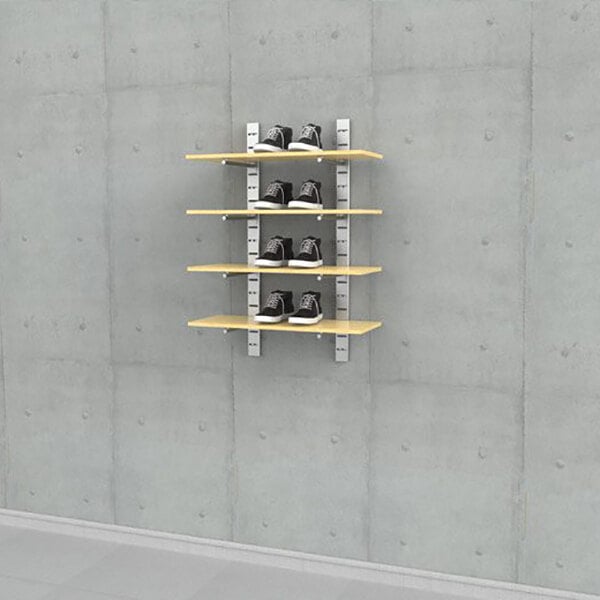 A wall-mounted retail display with four wooden shelves holding pairs of shoes.