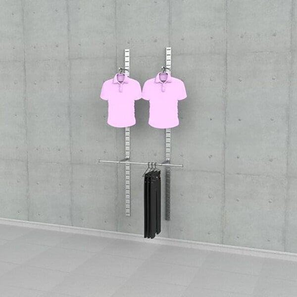A vertical wall-mounted retail clothing display with two faceouts holding shirts and one hanging rail with pants.