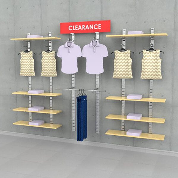 A wall-mounted retail clothing display system with shelves, hanging rails, and sign holders for showcasing apparel.