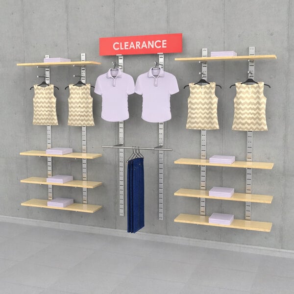 A vertical wall-mount retail clothing display system with three sections, featuring shelves, hanging rails, faceouts, and a clearance sign.
