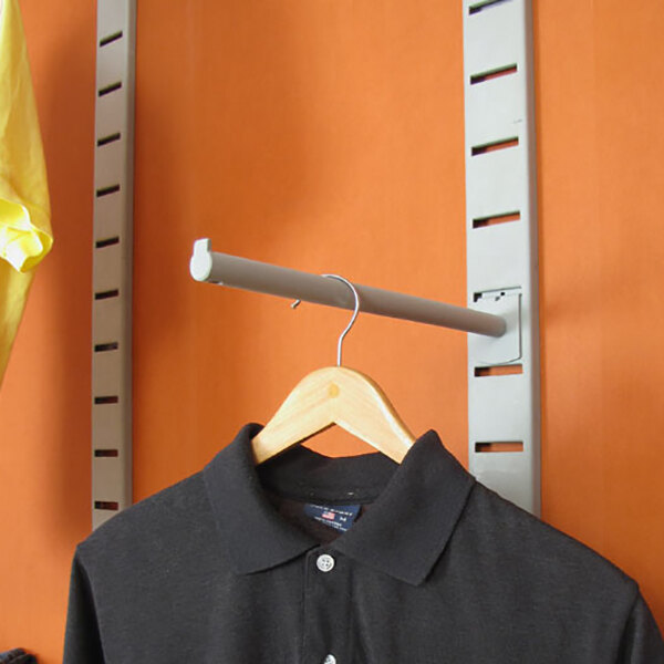 A vertical wall-mounted retail clothing display with a slatstrip and two faceouts, shown holding a shirt on a hanger.