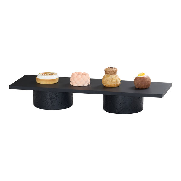 A rectangular midnight bamboo riser shelf with two cylindrical supports, designed for displaying items.