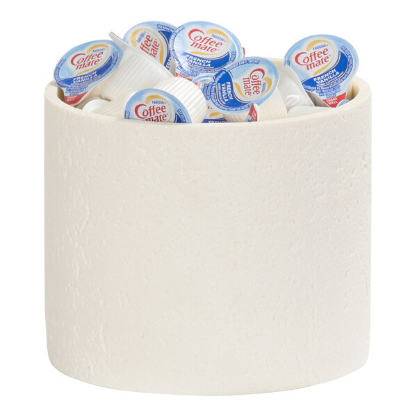 A round ivory resin riser holding individual Coffee-mate creamer cups.