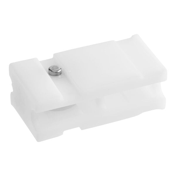 A white rectangular plastic component with a small metal pin and a visible wheel mechanism.