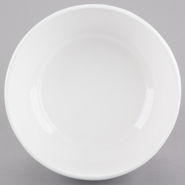 A white Tablecraft cast aluminum fruit bowl with a white rim.