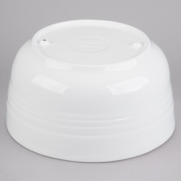 A white Tablecraft cast aluminum fruit bowl with a round top on a white surface.