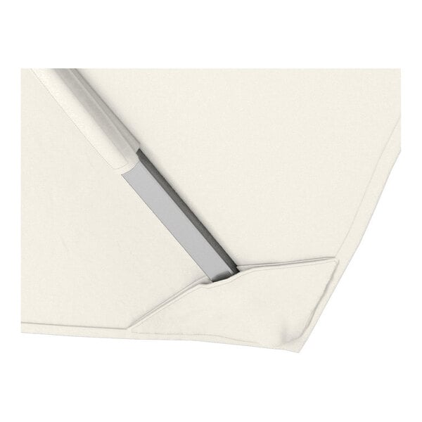 A close-up view of a natural-colored square cantilever umbrella with a silver aluminum frame and Sunbrella awning-grade canopy.